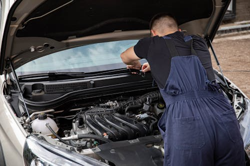 A professional fixing a car at a local auto shop