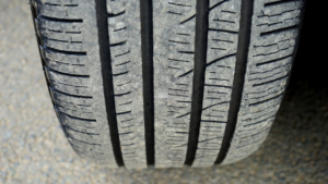 Close-up of a tire showing uneven tread wear with noticeably more wear on the inner edge