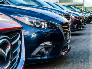 Row of clean, well-maintained vehicles lined up on a dealer lot ready for resale