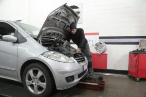 Mechanic inspecting engine components during a fuel system performance diagnosis