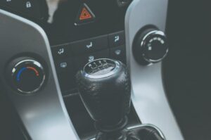 Manual gear shift inside a vehicle showing transmission-related warning signs