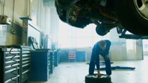 Mechanic inspecting a vehicle tire inside an auto repair shop
