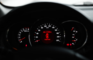 Close-up view of a car instrument cluster dashboard with an illuminated warning indicator showing engine trouble codes.