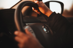 Close-up of hands turning a vehicle steering wheel where clicking noises often originate.