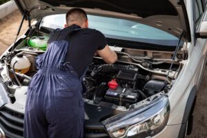 Technician inspecting engine components as part of seasonal vehicle maintenance